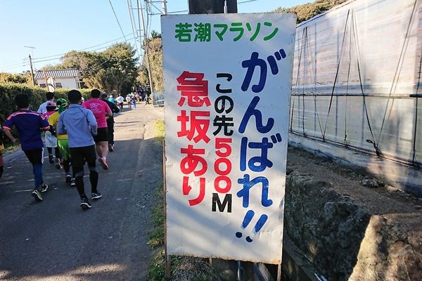 終盤は大きな上りが続く。「大会名物」の看板が沿道の声援と共にランナーを励ます？