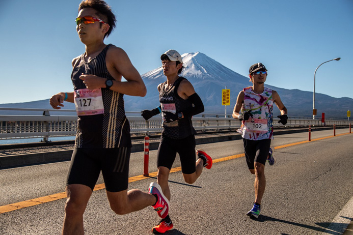 10km過ぎの河口湖大橋。真ん中の黒いユニフォームが2時間21分37秒で優勝した児玉雄介さん（35歳）