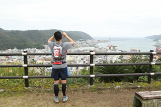 ゴールの名瀬市街地に近づくと視界が開けて海が見える！　晴れていれば真っ青な海のはずなのだが…